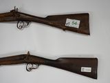 two old guns are displayed on a wall in a room