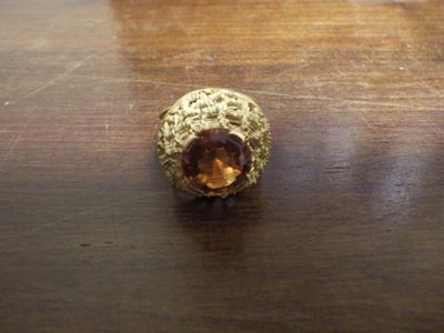 une bague en or sertie d'une citrine, posée sur une table