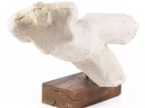 a white sculpture of a bird on a wooden base