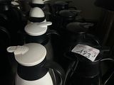 de nombreuses cafetières noires et blanches posées sur une table