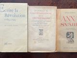 three books sitting on a table next to each other on top of a wooden table