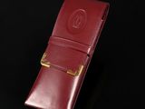 a close up of a red leather case on a black surface