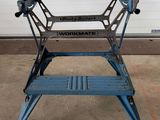 Une table de travail bleue est posée devant une porte de garage