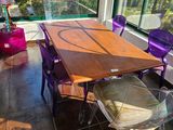 une table et des chaises dans une pièce avec une grande fenêtre