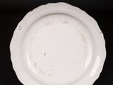 a close up of a white plate on a black surface