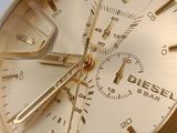 a close up of a gold watch on a white surface