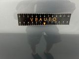 a man standing in front of a car holding a ruler