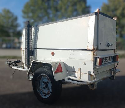 un camion blanc avec une remorque attelée à l'arrière