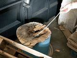 a man that is cutting a piece of wood with a knife