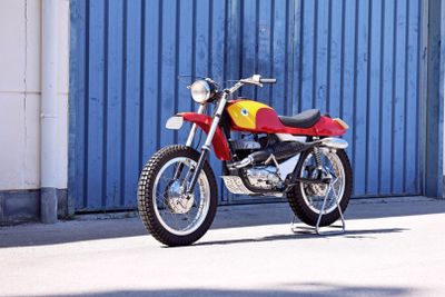 a red and yellow motorcycle parked in front of a blue garage door