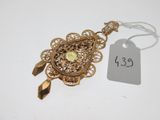 une photo d'un collier en or auquel est accrochée une étiquette