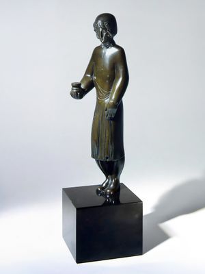 bronze statue of a man with a cup of coffee on a pedestal