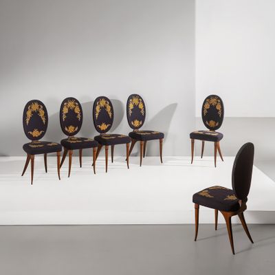 quatre chaises noires ornées de motifs à la feuille d'or dans une pièce blanche