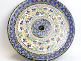 a decorative plate with blue flowers on it
