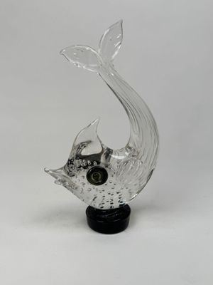 sculpture en verre représentant un poisson, posée sur un socle noir, sur fond blanc