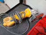 a corded sander on the floor next to a tool box