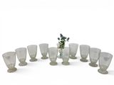 bottles and glasses are arranged in a circle on a white surface