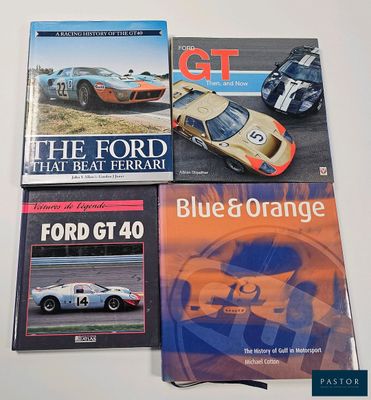 three books on a table with a picture of a racing car and a blue orange car