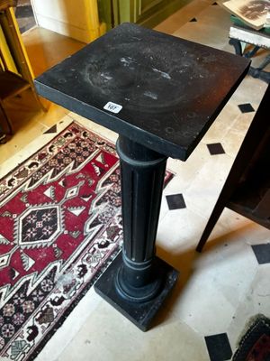 une petite table au plateau noir dans une pièce