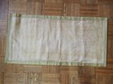 a table runner on a wooden floor with a green border