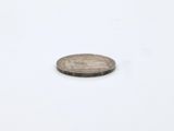 a small coin that is sitting on a white surface
