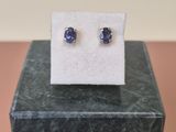 une paire de boucles d'oreilles en saphir bleu posées sur un bloc de marbre