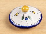 a small blue and white plate with a yellow flower on it