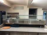 plan de travail en acier inoxydable dans une cuisine professionnelle équipée d'une vitrine en verre