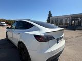 a white tesla suv parked in a parking lot next to a building