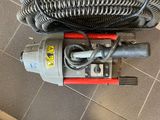 a vacuum that is sitting on the floor next to a hose