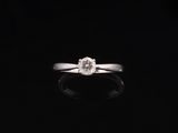 a close up of a diamond ring on a black surface