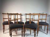 quatre chaises en bois, dotées de coussins rembourrés, sont disposées en rangée