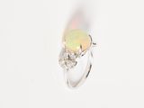 an oplite and diamond ring on a white background