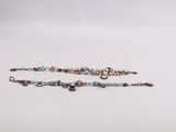 a close up of a beaded bracelet on a white surface