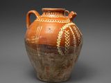 vase marron et blanc orné de motifs sur un fond gris