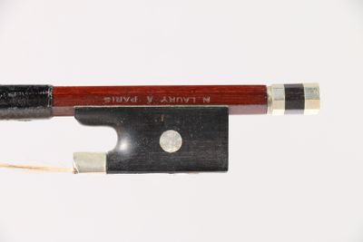 a violin bow and a bow rest on a white surface