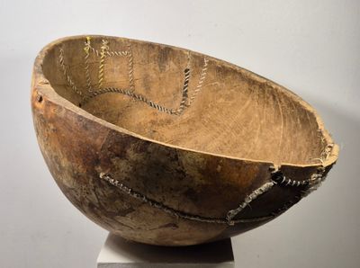 un grand bol en bois posé sur un socle blanc