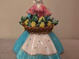 une figurine représentant une femme tenant un panier de raisins