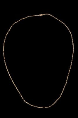un collier en or dont la chaîne est mise en valeur sur un fond noir