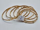 un lot de six bracelets de couleur dorée, avec une étiquette de prix