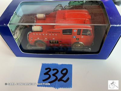 un camion de pompiers rouge dans une boîte bleue posée sur une table