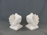 deux figurines en céramique blanche représentant un oiseau, posées sur un socle
