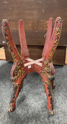 une paire de chaises en bois peintes en rouge et or, posées sur un sol recouvert de moquette