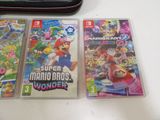 three nintendo wii games sitting on top of a table next to a laptop