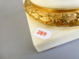 a white and gold vase on a marble base