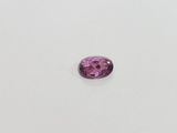 a pink tourmaline gems on a white surface