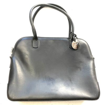 a close up of a black handbag on a white surface