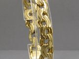 an image of a gold plated bracelet on a clear stand