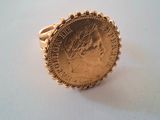 a close up of a gold coin ring on a white surface
