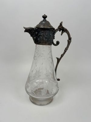 un pichet ancien en verre plaqué argent sur fond blanc